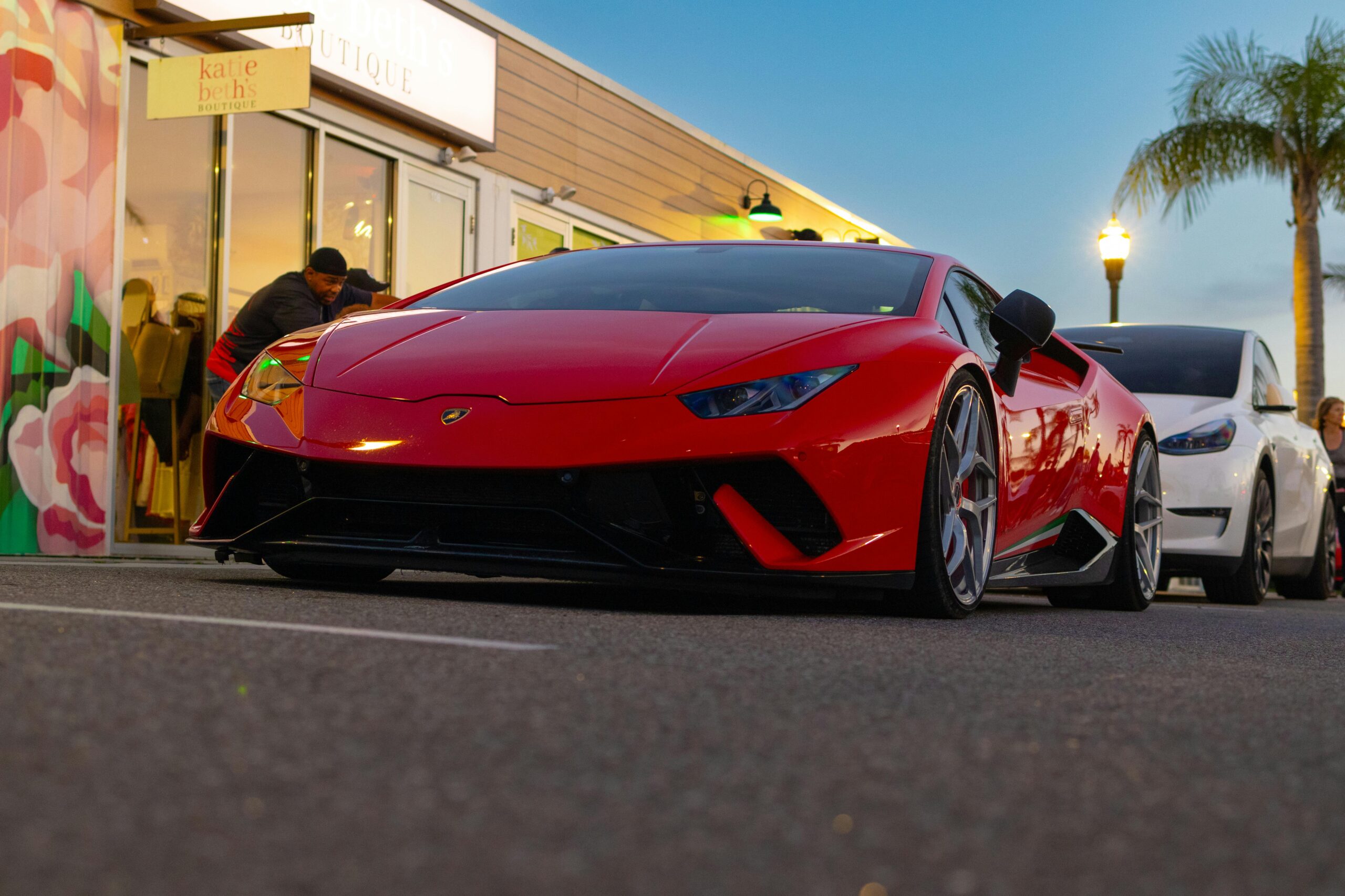 Red Lamborghini Huracan parked outdoors at sunset, showcasing sleek design and luxury.